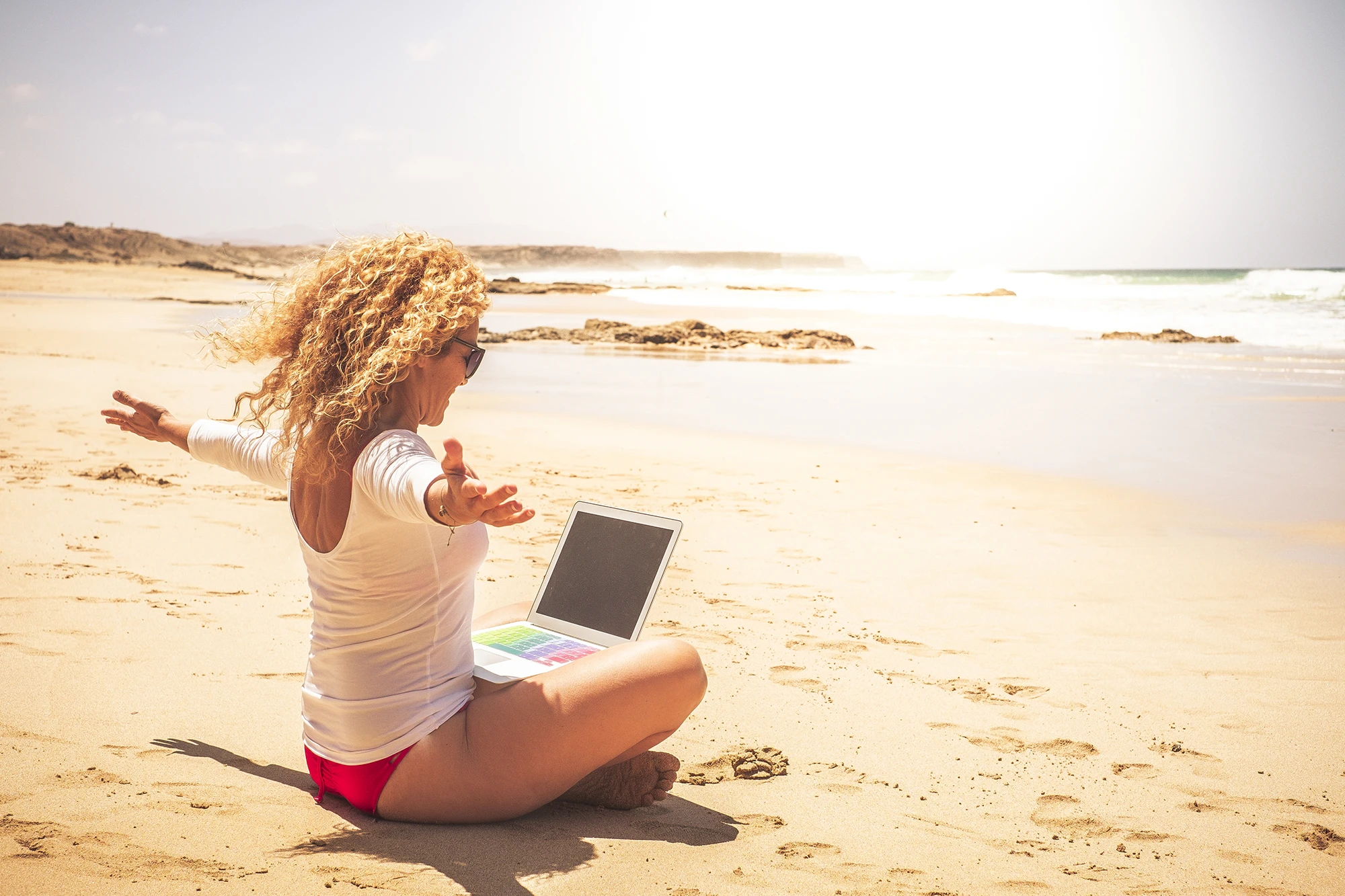 Mulher na praia praticando a energia criativa.